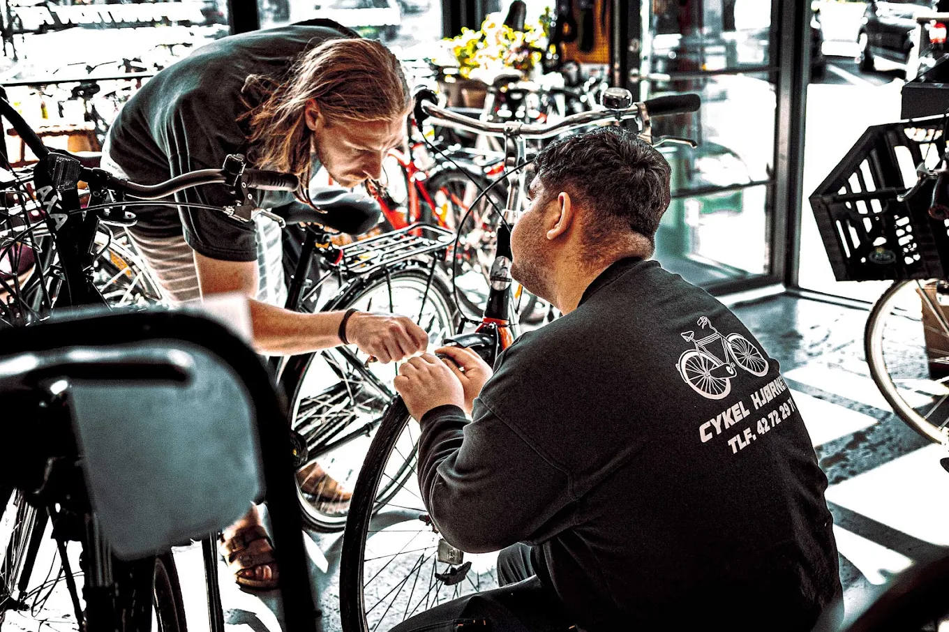 Mekaniker reparerer en cykel i værkstedet